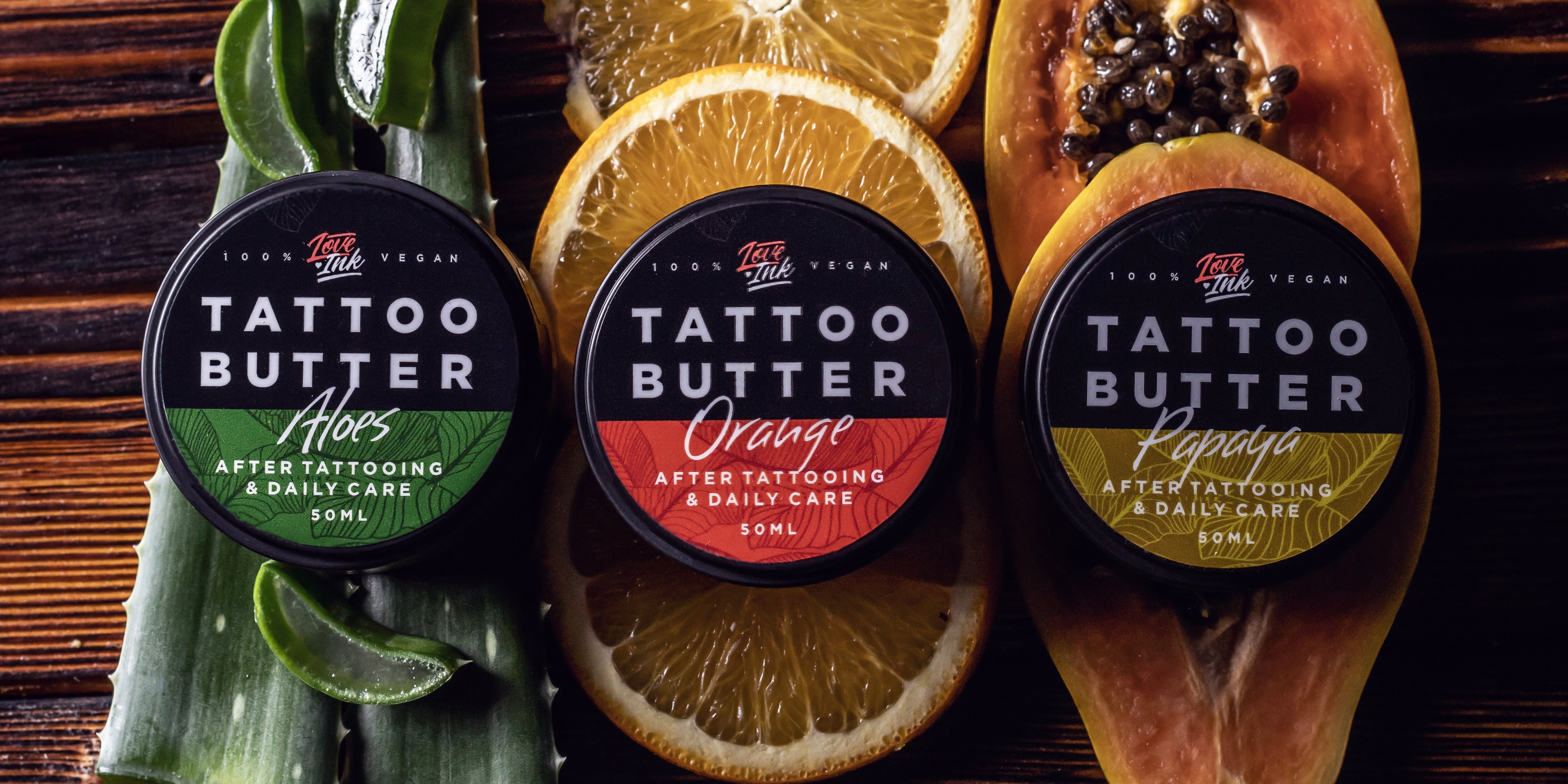 Baner Tattoo Butter Aloes orange papaya na liściach aloesu, plastrach pomarańczy i owocu papaja