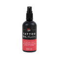 Na zdjęciu znajduje się butelka oleju do tatuaży o zapachu malinowym od marki Love Ink. Butelka jest czarna z różową etykietą i napisem "Tattoo Oil Raspberry". Etykieta informuje, że olej jest w 99% pochodzenia naturalnego i przeznaczony do pielęgnacji po tatuażu oraz do codziennego użytku. Pojemność butelki wynosi 100 ml. Design jest prosty i nowoczesny, podkreślający naturalny i wegański charakter produktu.